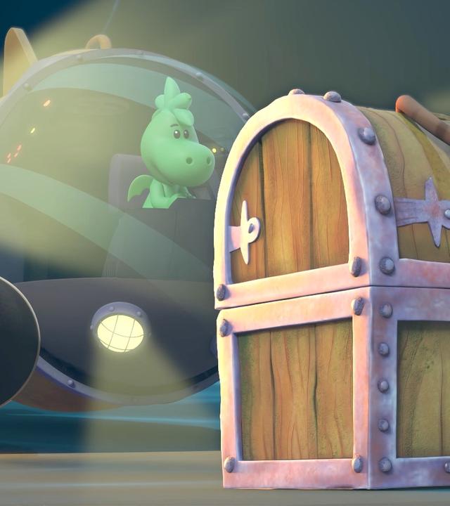 Grisu ist mit einem Unterseeboot auf den Meeresgrund getaucht. Im Vordergrund des Bildes steht eine große, alte Piratenschatztruhe. Grisu betrachtet aus der Glaskuppel des U-Bootes die Schatzkiste und bestaunt sie.