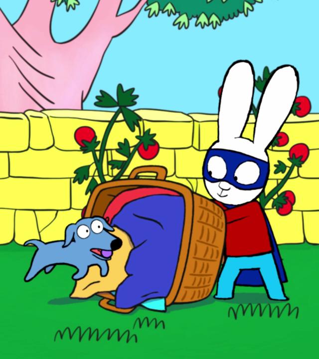 Franz und Simon sind als Superhelden verkleidet und spielen im Garten mit Hund Elvis. Simon steht hinter einem umgekippten Wäschekorb mit bunter Wäsche darin. Elvis läuft auf Simon zu und Franz läuft hinter Elvis her. Im Hintergrund stehen Tomatensträucher.