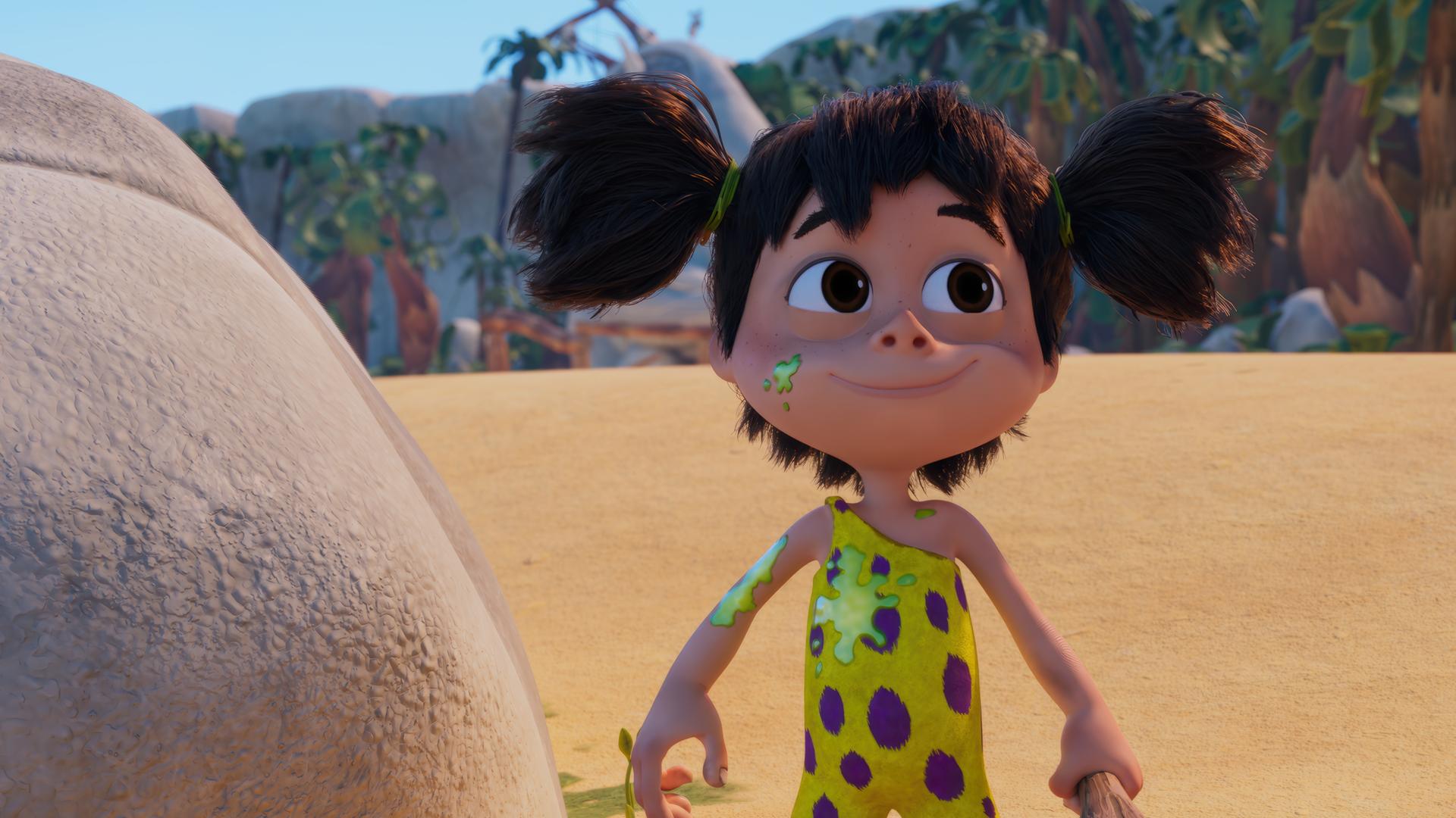 Das Urzeitmädchen Lucy mit den dunklen Zöpfen und den Kulleraugen hat grüne Flecken auf ihrem gelb-lilafarbenen Fellhosenanzug. Trotzdem blickt sie zufrieden drein, ihre Keule in der Hand.