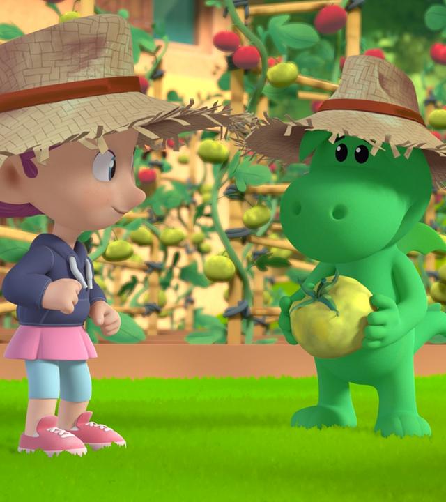 Grisu, der kleine Drache, betrachtet eine Reihe von Tomatenstauden. Seine Freundin Stella ist bei ihm und scheint darauf zu warten, dass die Tomatenernte beginnt.
