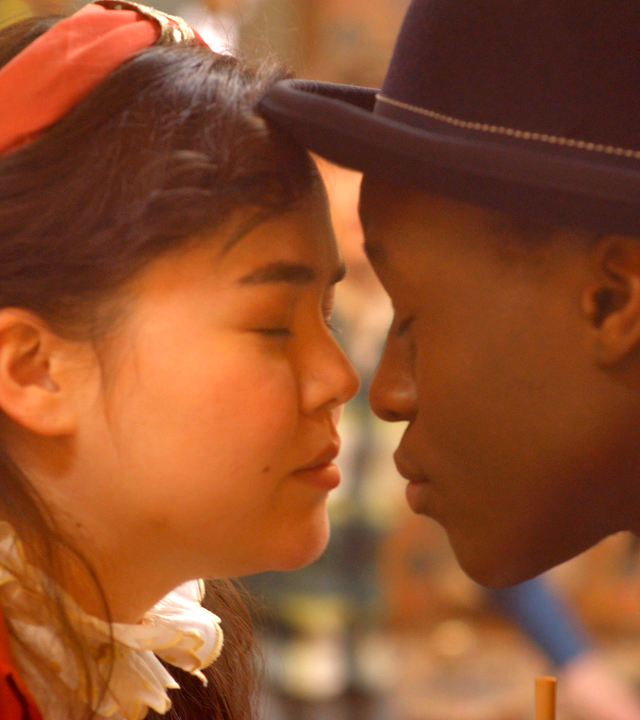 Josie und Will sind mit den Köpfen ganz nah. Ihre Augen sind geschlossen und ihre Nasen berühren sich fast.