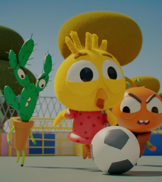 Auf einem umzäunten Fußballplatz laufen Heinz, der Tomaten-Junge und Karla, das Küken auf einen Fußball zu. Beide sind bereit zum Schutz. Heinz blickt grimmig zum Ball; Karla konzentriert.