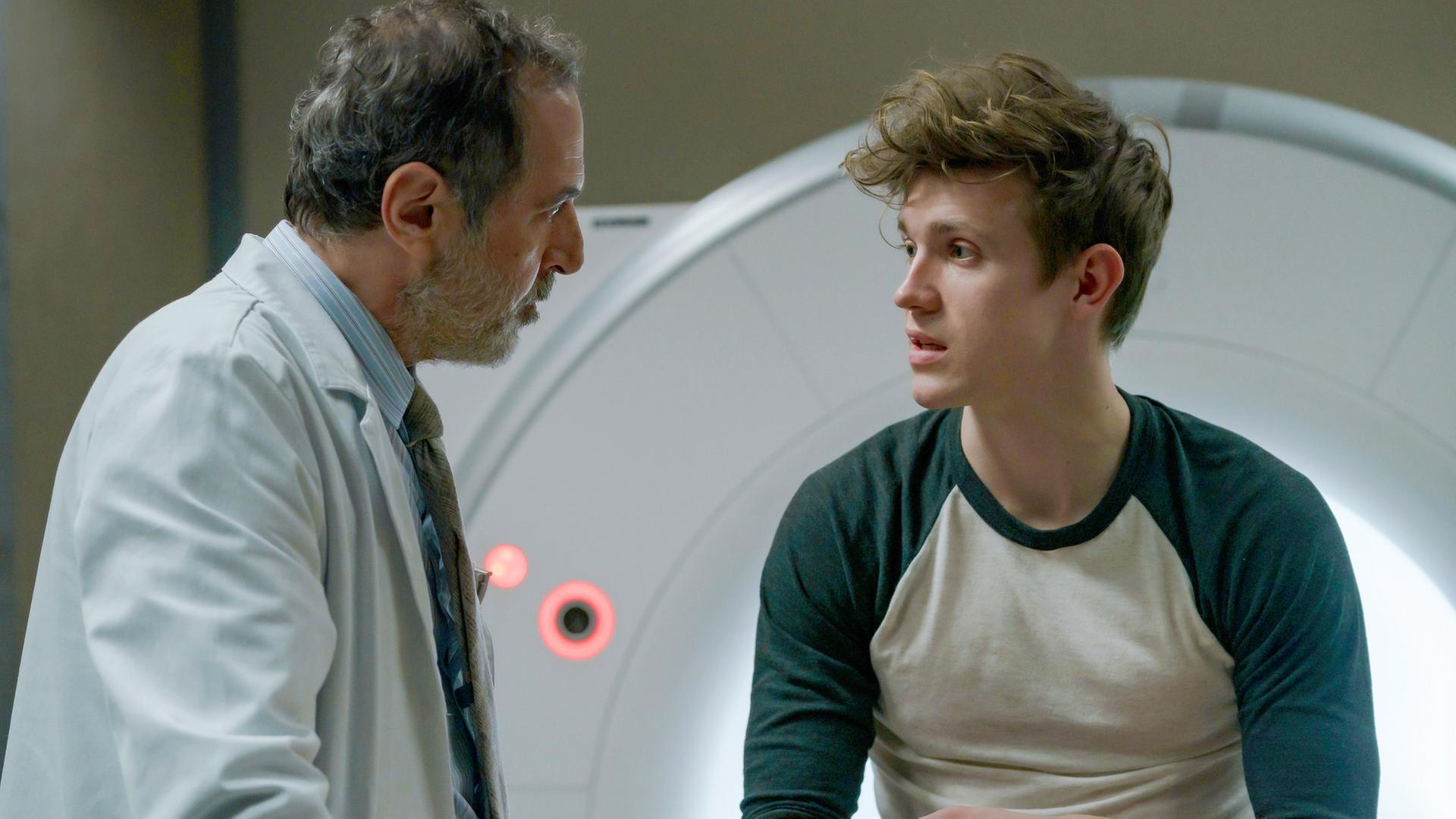 Lukas spricht mit Dr. Ballouz, während er vor dem MRT sitzt.