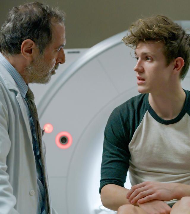 Lukas spricht mit Dr. Ballouz, während er vor dem MRT sitzt.