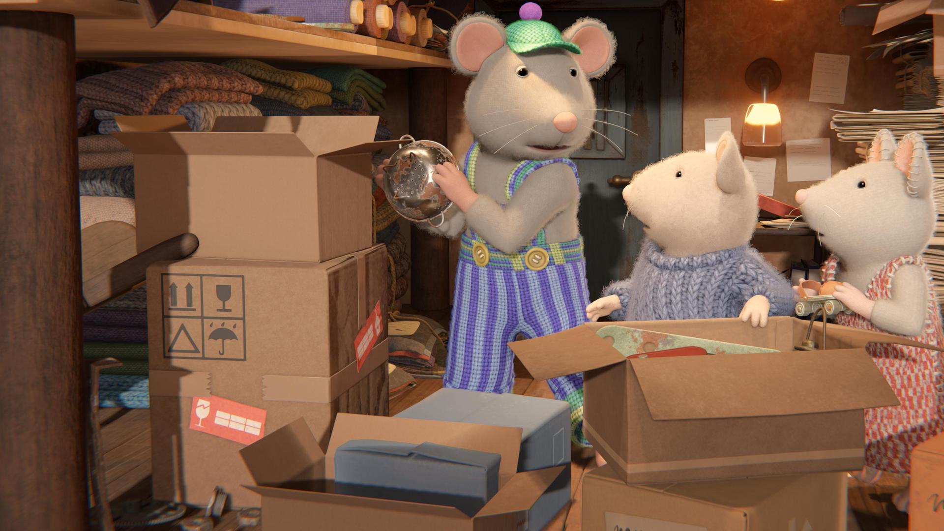 Sam und Julia stehen vor einem großen, aufgeklappten Karton und schauen von der Seite auf Onkel Lumpi, der im Keller ein Sieb in eine Kiste räumt.