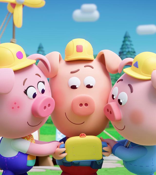 Drei Schweinchen mit Bauarbeiter-Helmen, die Werkel-Ferkel, spielen gemeinsam ein gelbes, kleines Videospiel. 