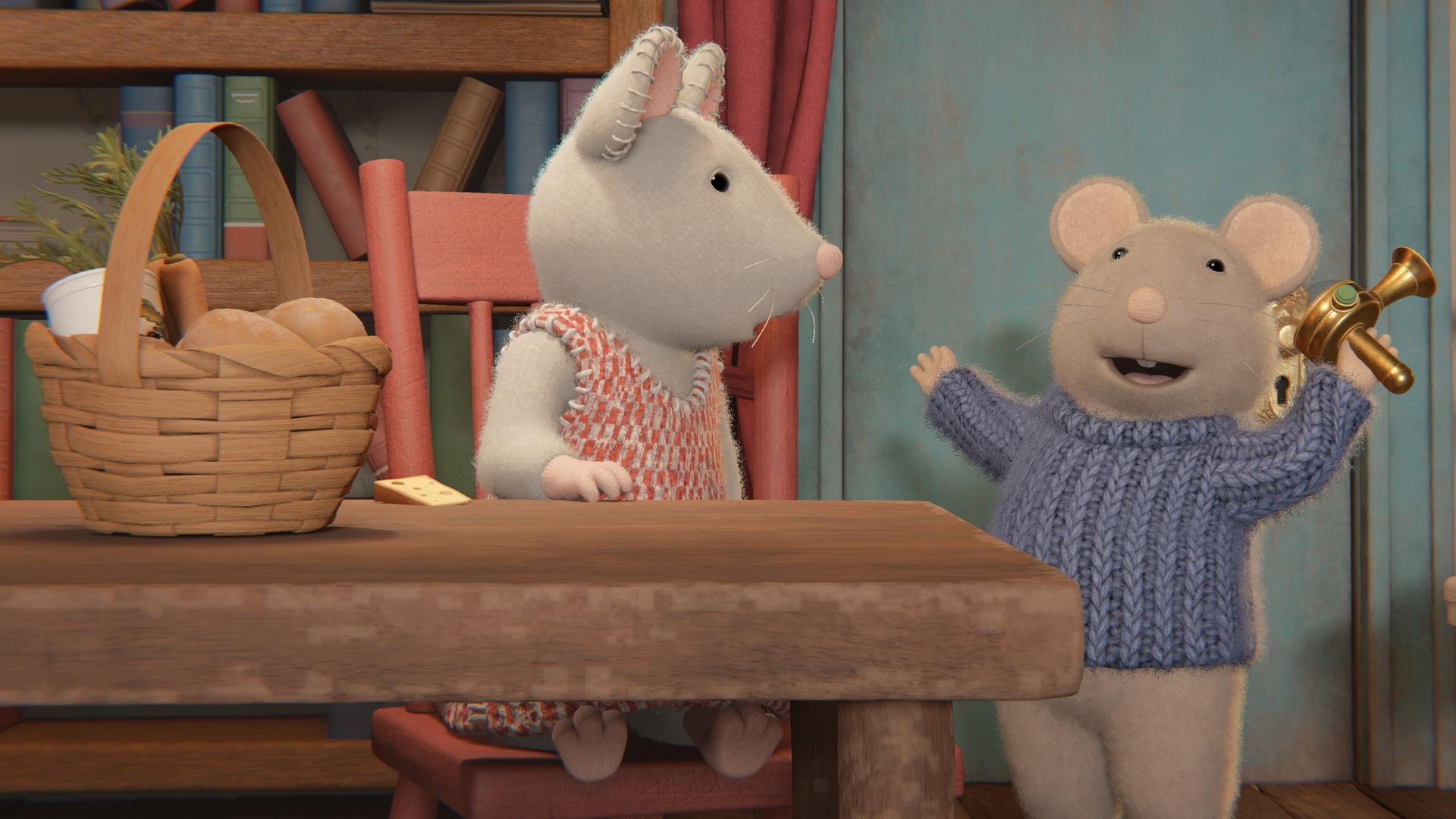 Julia sitzt an einem Tisch im Wohnzimmer vor einem Bücherregal und schaut zu Sam. Der steht vor ihr und hat ein Gerät aus Metall in der linken Hand.