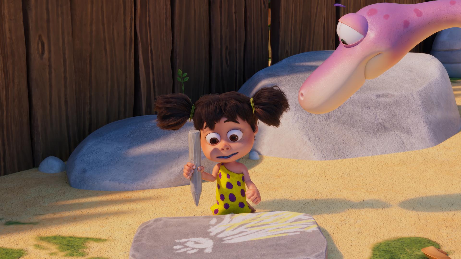 Lucy, das Urzeitmädchen, sitzt vor einer Steintafel, auf die sie mit einem Steinstift einen Kometen mit Schweif gemalt hat. Von der Seite schaut ihr der rosafarbene Dino Minus Drei beim Malen zu.