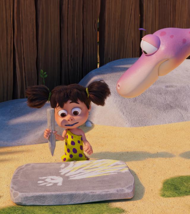 Lucy, das Urzeitmädchen, sitzt vor einer Steintafel, auf die sie mit einem Steinstift einen Kometen mit Schweif gemalt hat. Von der Seite schaut ihr der rosafarbene Dino Minus Drei beim Malen zu.