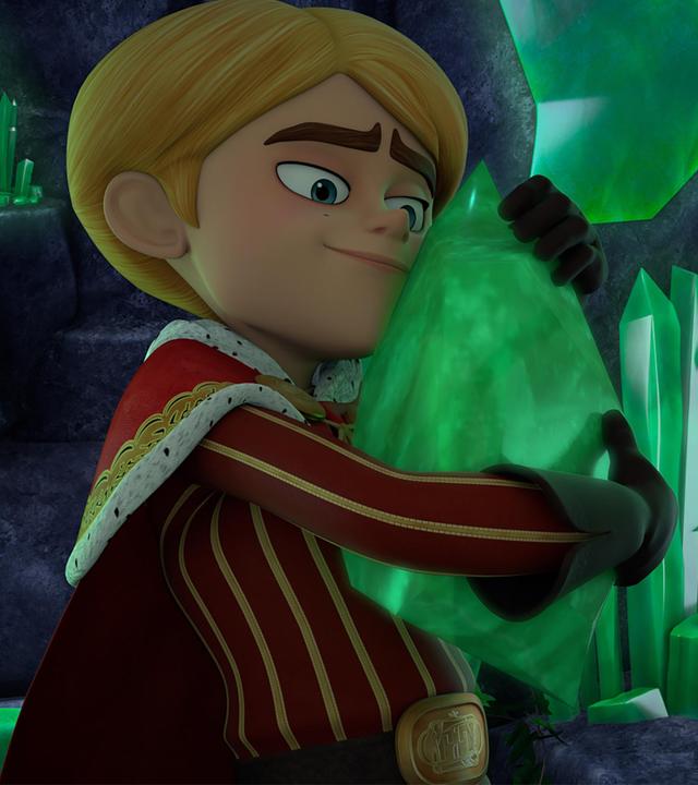 In einer dunklen, felsigen Höhle hält Prinz John fast zärtlich einen großen, grün schimmernden Smaragd in seinen Händen und presst ihn an seinen Oberkörper. Dabei lächelt er glücklich. Um ihn herum sind viele dieser Smaragdkristalle in unterschiedlichen Formen und Größen.