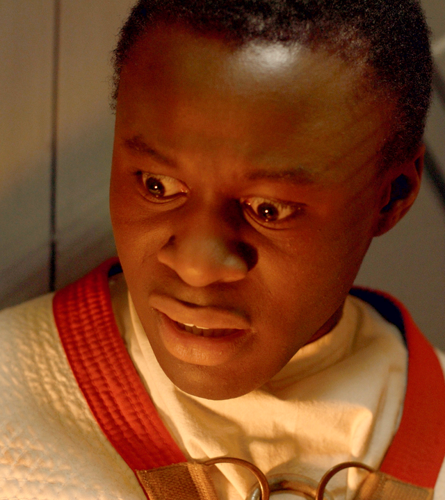 Will ist eingesperrt in einem Holz-Schrein und schaut entsetzt nach unten in die Flammen, die anscheinend unter ihm lodern.