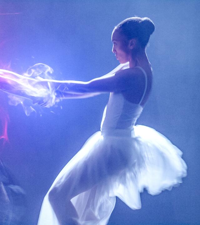 Jade und Cece tanzen miteinander auf der Bühne. Jade trägt ein schwarzes, Cece ein weißes Ballettkleid. Sie halten sich an den Händen und es kommt zu magischen Funken.