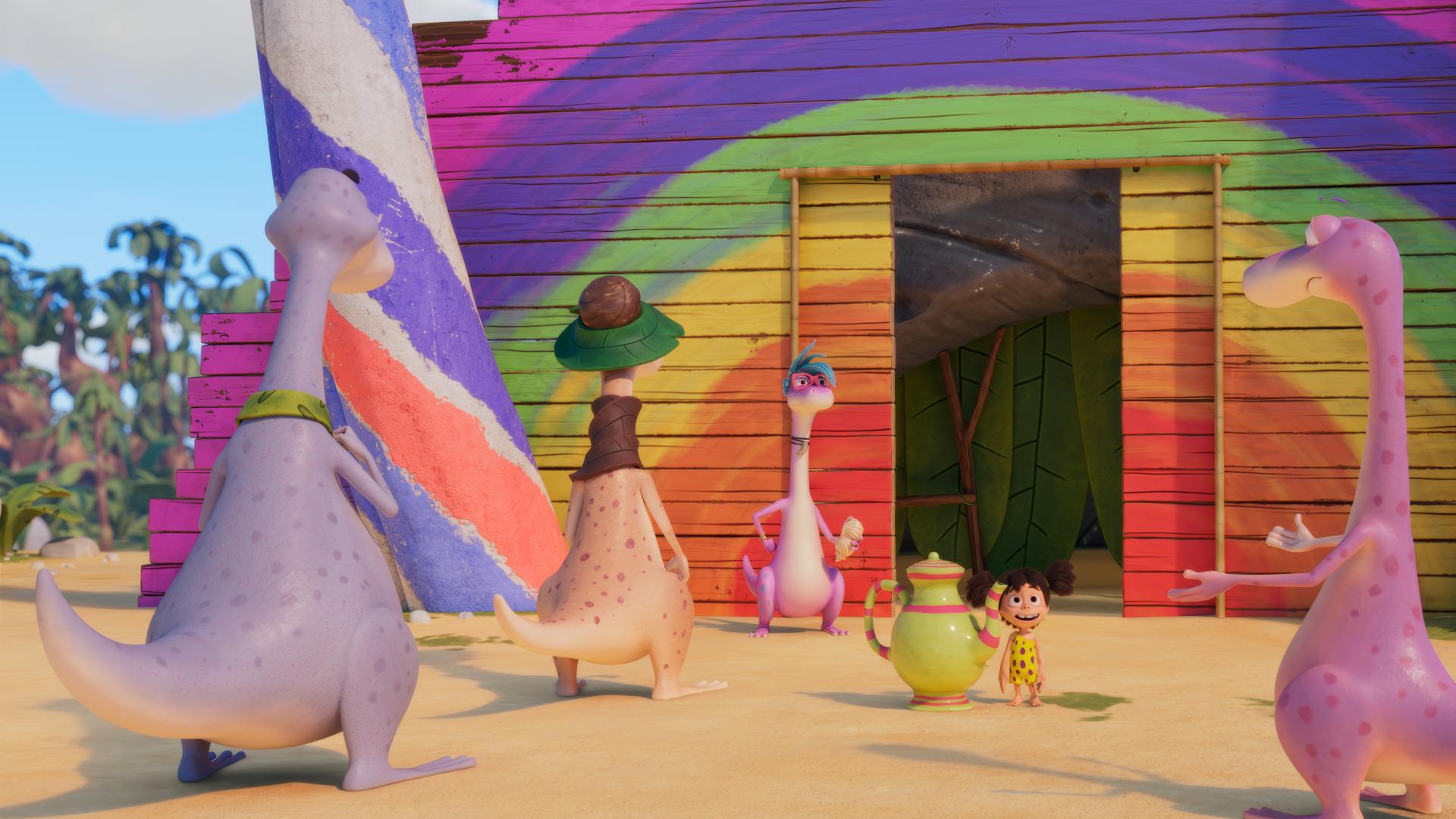 Wir sehen im Hintergrund eine Regenbogenfarbene Bretterwand, in die eine Schiebetür eingelassen ist. Vor der Tür hat sich eine Dinosaurier-Schlange gebildet. Lucy steht ebenfalls davor, sie hat eine riesige Tee-Kanne neben sich und strahlt Minus Drei an, der vor ihr steht und scheinbar nicht glauben kann, was er da gerade sieht.