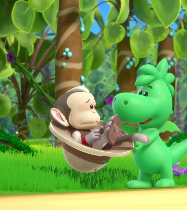Grisu, der kleine Drache, hält einen Tropenhelm in den Händen. In diesem Tropenhelm sitzt ein traurig blickender Affe. Um sie herum ist ein grüner Urwald.