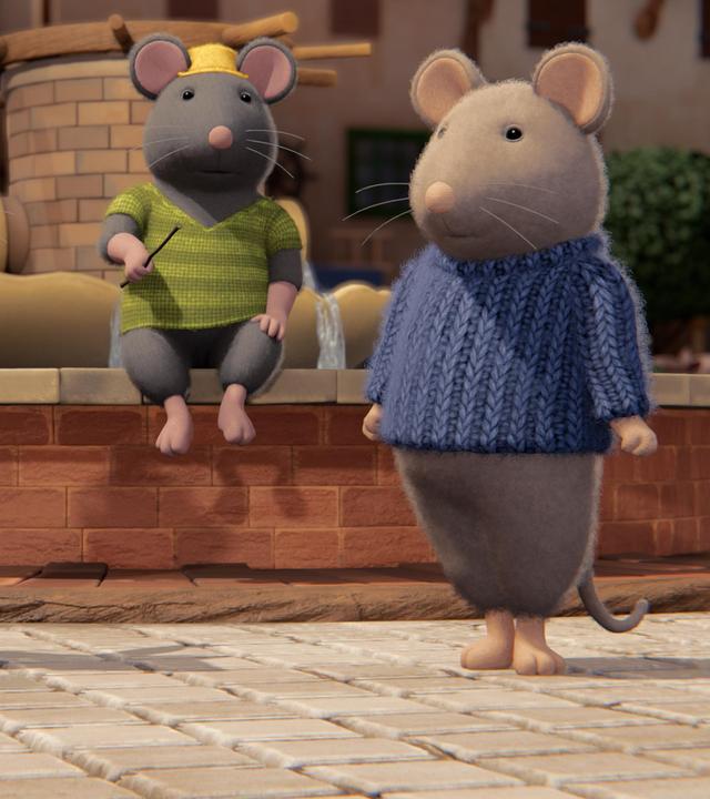 Tonio sitzt regungslos auf dem Brunnenrand im Hof des Mäusehauses. Er hält einen Stab in der rechten Hand. Julia und Sam stehen seitlich vor ihm und schauen erstaunt zu ihm hoch.