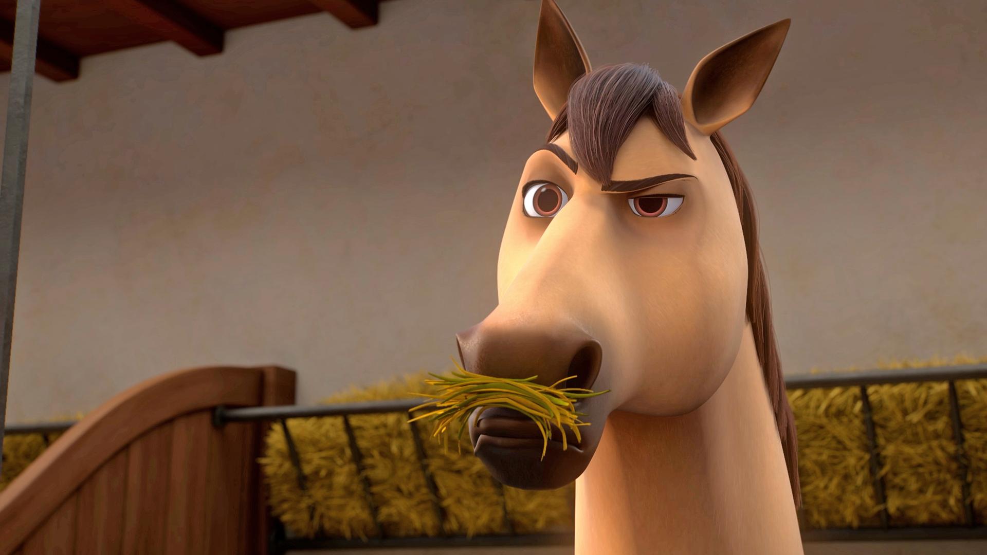 D'Artagnans Pferd Planchet, ein Falbe mit schwarzer Mähne, steht in seiner Box und frisst Heu. Er schaut skeptisch nach vorne.