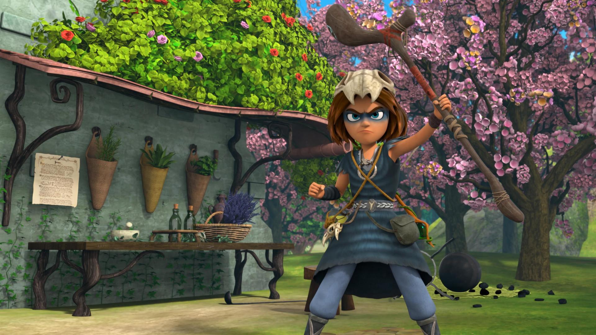 Auf einem gepflasterten Weg im erblühten Garten vor Katells Haus steht der Schamanenjunge Stig. Seinen Druidenstab hält er mutig und stolz nach oben und sein Blick ist entschlossen.