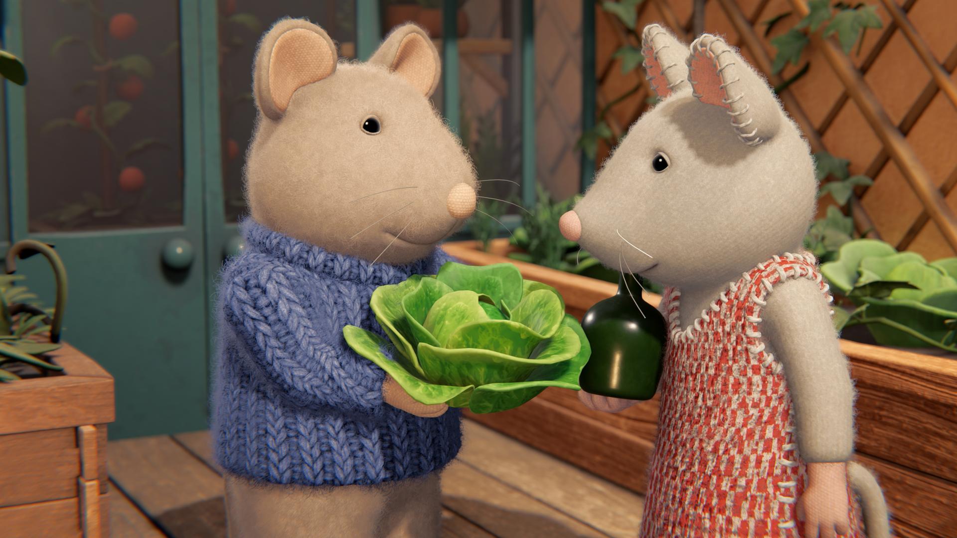 Sam und Julia stehen auf der Terrasse zwischen Hochbeeten mit Salatköpfen. Sam hält einen Salatkopf in den Händen und zeigt ihn Julia.