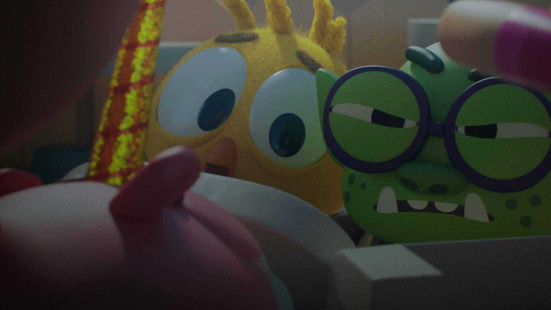 Das Küken Karla und Troll Oggi blicken angespannt und verängstigt nach vorne. Ihre Körper sind nicht vollständig sichtbar, da sie sich hinter einem Zaun verbarrikadiert haben. Das Einhorn-Schwein Ophelia steht auf der anderen Seite des Zauns und versucht zu ihnen vorzudringen.