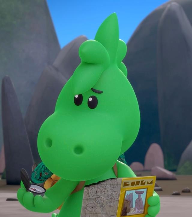 Grisu, der kleine Drache, ist mit seiner Freundin Stella im Drachental unterwegs. Er trägt einen Wanderrucksack und liest eine Landkarte.
