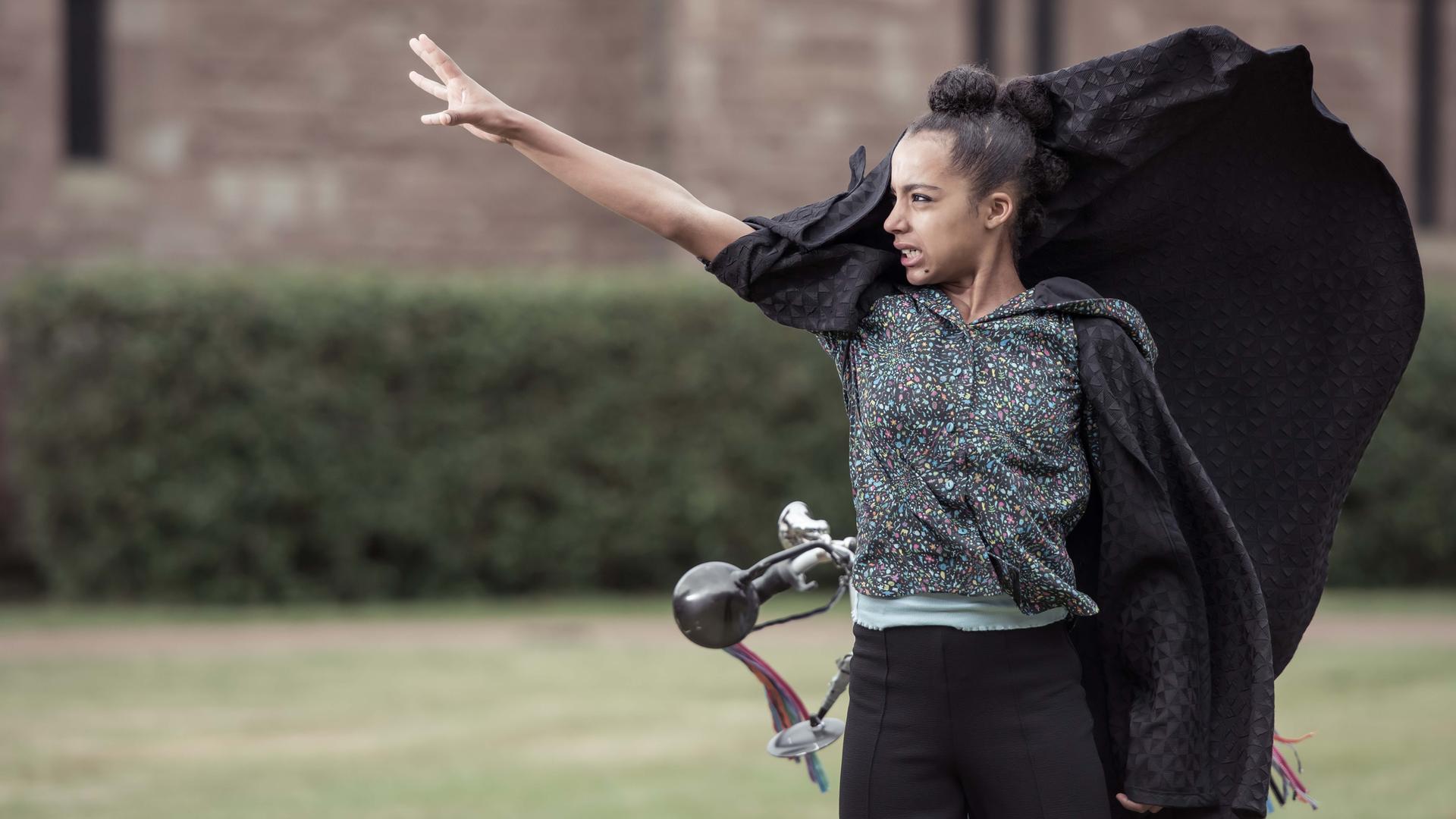 Indigo steht auf dem Rasen mit erhobenem rechten Arm und schaut bedrohlich.