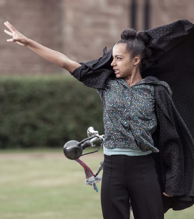 Indigo steht auf dem Rasen mit erhobenem rechten Arm und schaut bedrohlich.