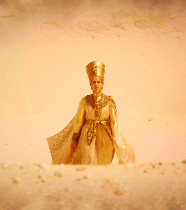 Hatschepsut erscheint Theodosia in einer Vision: Sie läuft durch eine Wüstenlandschaft und trägt das goldverzierte Gewand einer Pharaonin.