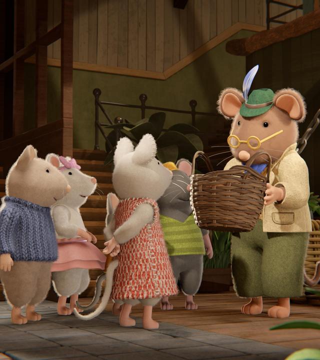 Im Eingangsbereich des Mäusehauses steht Herr Grummel mit einem geflochtenen Korb mit Käsesternen in den Händen und erklärt etwas. Um ihn herum stehen im Halbkreis Sam, Ella, Julia und Tonio und lauschen ihm aufmerksam.