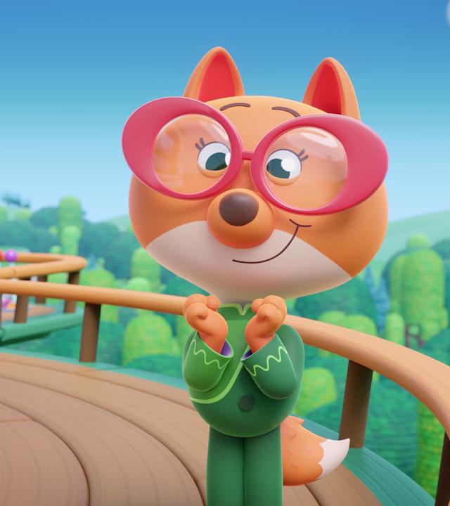 Im Bild sehen wir eine aufgeregte Fiona. Fiona ist eine Füchsin mit großer, roter Brille und einem grünen Hosenanzug. Sie steht auf der Terrasse ihrer Jurte. Man sieht am Himmel am Hintergrund, dass die Jurte fliegt!