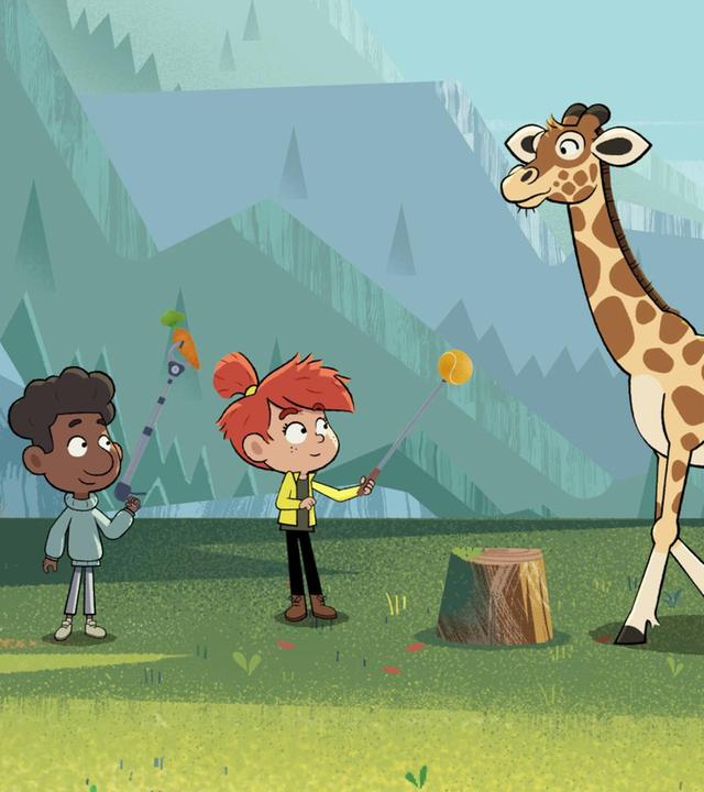 Taylor und Tommy stehen mit einem Trainingsstab in der Hand vor einer Giraffe. Ruth schaut ihnen zu.