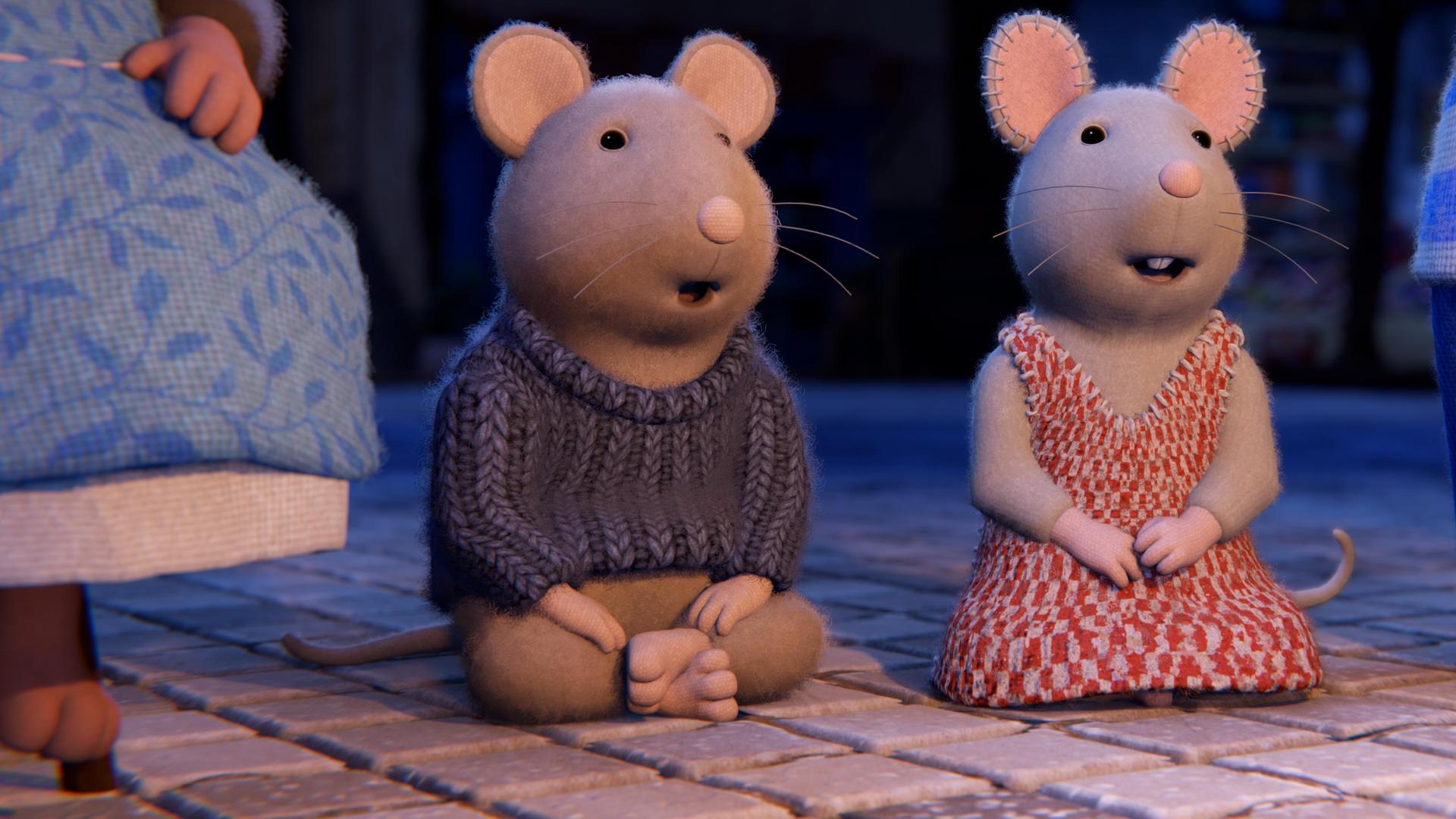 Sam und Julia hocken auf dem gepflasterten Boden und schauen aufmerksam und begeistert nach vorne. Neben ihnen sieht man die Beine von erwachsenen Hausbewohnern.