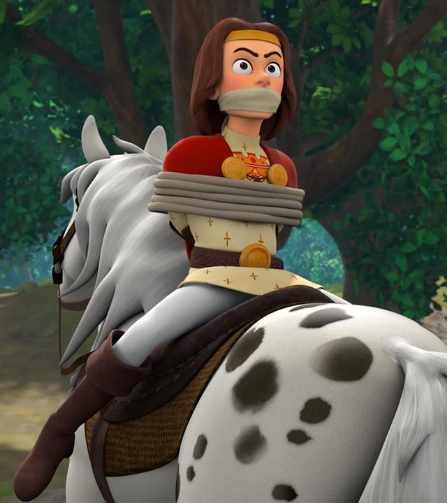  Auf einem Waldweg sitzt König Richard gefesselt, verkehrt herum auf einem Pferd. Marian, die daneben seitlich auf einem Pferd sitzt, blickt ängstlich nach vorne.