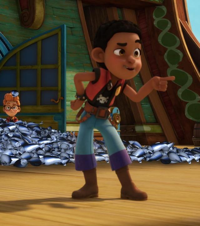 In einem Berg von toten Fischen sitzen Alexander und Zoe. Finn steht weit vorne dran und zeigt hämisch mit seinem Zeigefinger nach vorne.