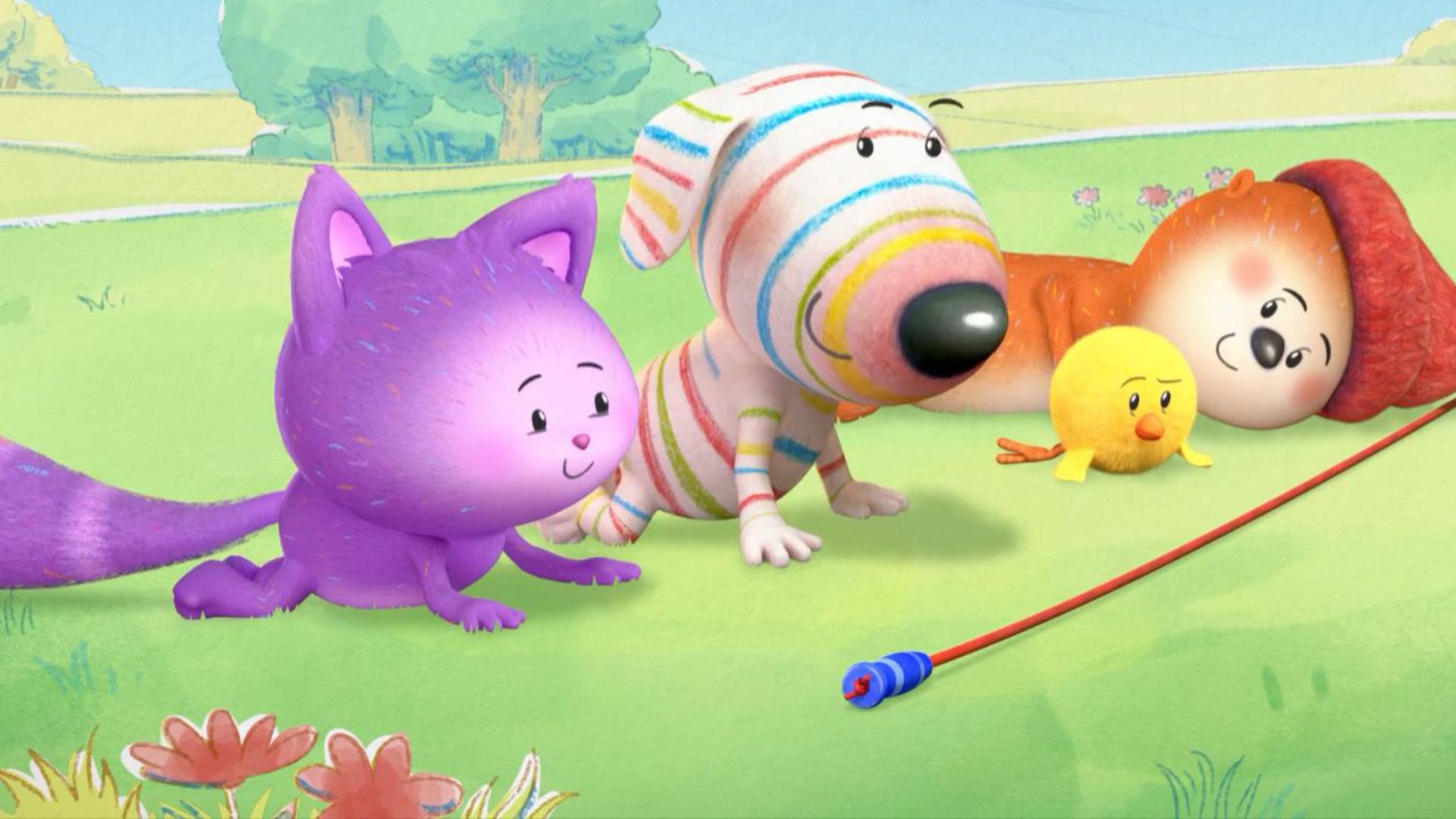 Nebeneinander auf einer Wiese liegen Katze Daisy, Hund Dylan, Küken Bitsy und Otter Ozzy. Vor ihnen liegt ein langgezogenes Springseil, das wie die Ziellinie eines Wettbewerbs aussieht.