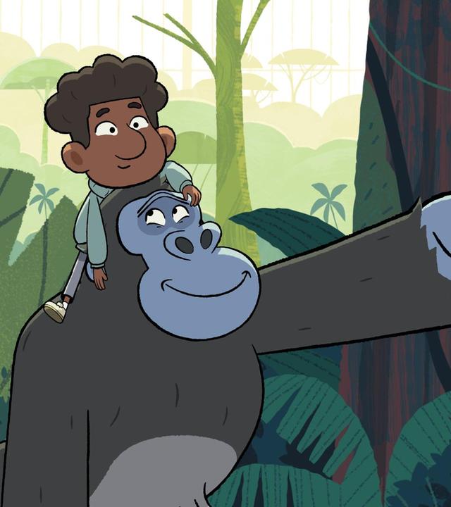 Gorilla Jack trägt Tommy auf den Schultern und zeigt freundlich lächelnd nach vorne.