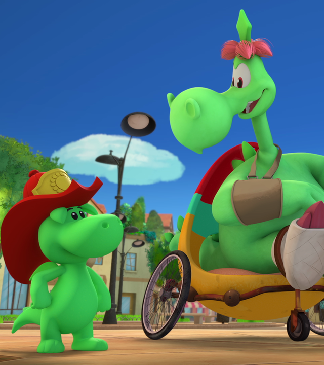 Der große, grüne Drache Fumé sitzt in einem lustig zusammengebauten Rollstuhl -  sein Bein ist in Gips und sein Arm in einer Schlinge. Neben ihm stehen Grisu, sein Sohn und dessen Freundin Stella. Sie sind auf einem Platz in Drachenstadt.