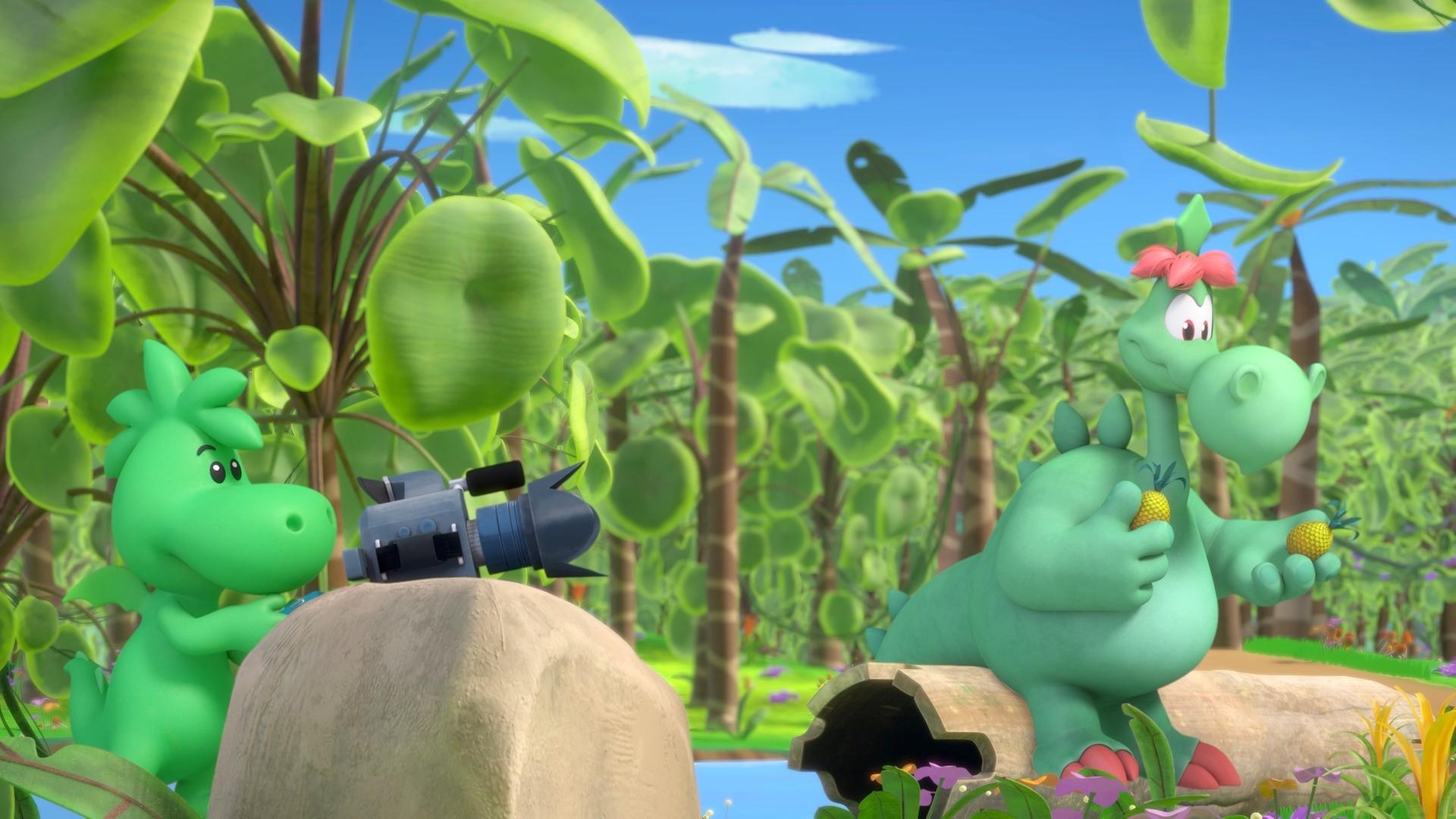 Grisu, der kleine Drache, und sein Vater Fumé sind im Urwald. Grisu betätigt eine Filmkamera, die auf einem Stein vor ihm liegt. Fumé sitzt etwas abseits auf einem Baumstumpf und hält Ananas in den Händen.