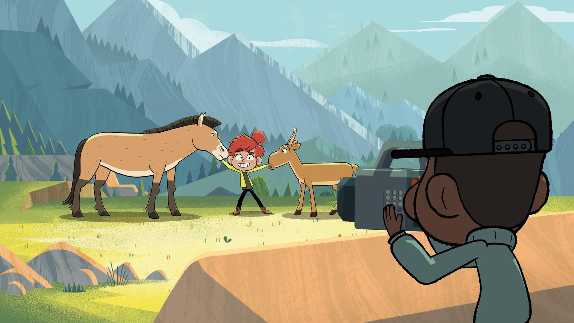 Taylor steht vor einer Bergkulisse. Links und rechts von ihr hält sie ein Pferd und einen Bock fest. Sie lächelt gekünstelt und im Vordergrund sieht man Tommy, der die Szene filmt.