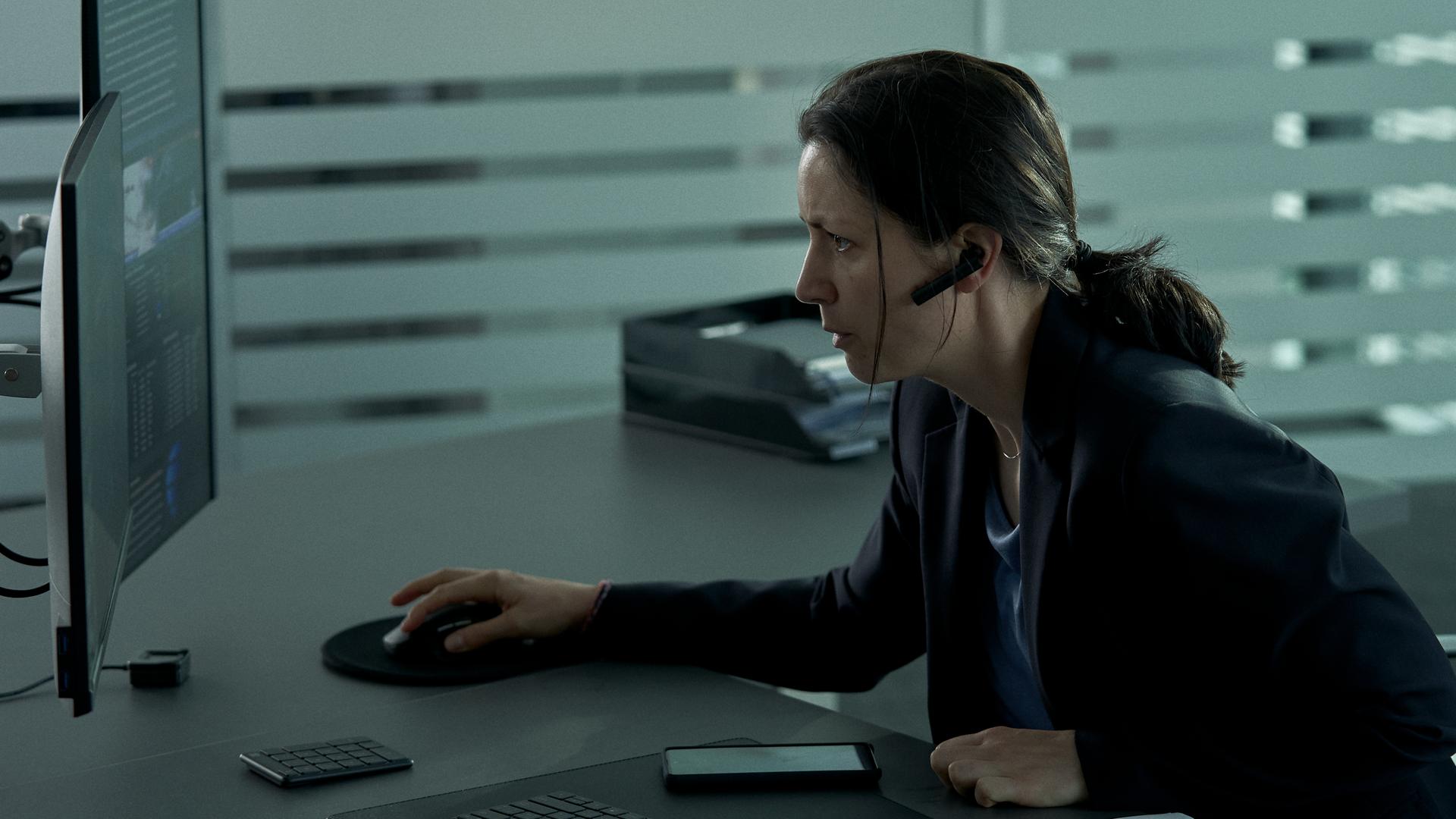 Vera (Eva Meckbach) sitzt vor dem Computer.