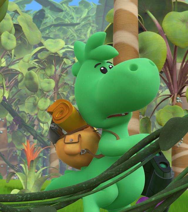 Grisu, der kleine grüne Drache, trägt einen Rucksack auf dem Rücken. Er ist in einem bunten Dschungel unterwegs. Er hält ein Fernglas in der Hand und schaut suchend nach oben.