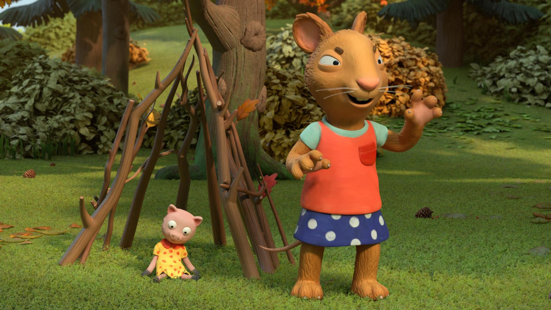 Im Park steht die Maus Posy, fies und grimmig blickend mit gefährlich erhobenen Händen vor einem aus Stöcken gebauten Kerker. Darin sitzt das Kuscheltier Schweinchen. Die Laubbäume sind herbstlich gefärbt.
