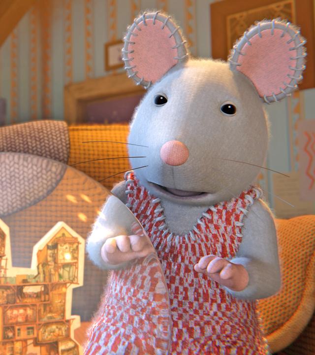 Sam und Julia sitzen auf einem Sofa in einem Zimmer mit gestreifter Tapete. Sie schauen hoffnungsvoll auf ein Modell des Mäusehauses in einer Schneekugel.