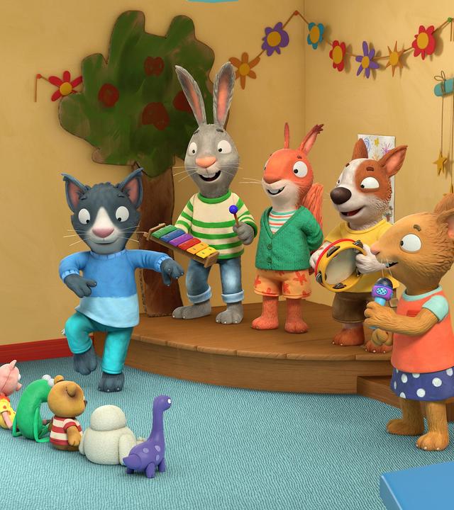 Im Haus auf der Bühne in der Ecke des Spielzimmers: Die Freunde spielen als Band zusammen und Kater Mo tanzt ausgelassen auf dem Teppich davor. Das Kaninchen Pip spielt Xylophon, das Eichhörnchen Jamila lächelt, der Hund Zac schlägt im Takt auf ein Tamburin und die Maus Posy hält ein Mikrofon in der Hand. Als Zuschauer sitzen Stofftiere in einer Reihe auf dem Teppich vor der Bühne.