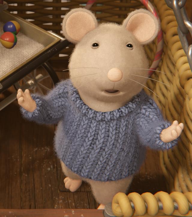 Sam steht in einem großen Korb mit einem Kinderwagen voller Zauberartikel und breitet die Arme aus, um seine Vorstellung zu beginnen.