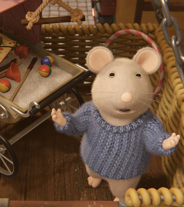 Sam steht in einem großen Korb mit einem Kinderwagen voller Zauberartikel und breitet die Arme aus, um seine Vorstellung zu beginnen.