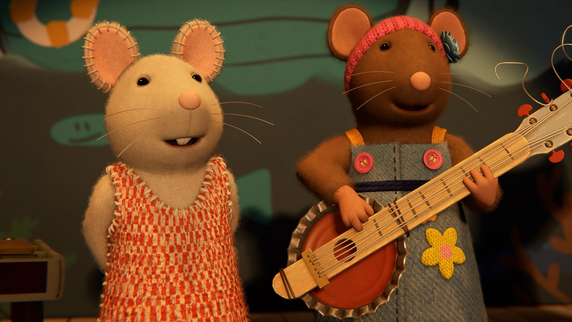 Julia singt und Sarah spielt Gitarre auf der Bühne im Mäusehaus. Hinter ihnen ist die Wand bemalt mit Fischen, einem Boot, einem Rettungsring und Wasserpflanzen.