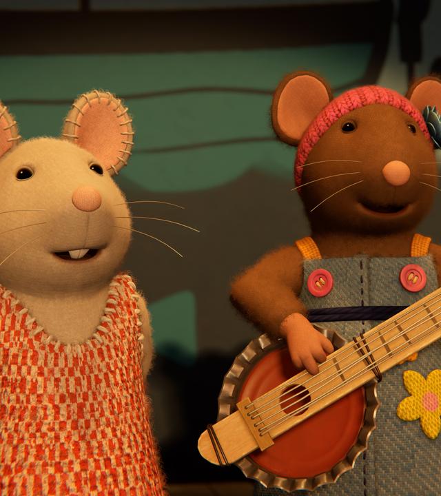 Julia singt und Sarah spielt Gitarre auf der Bühne im Mäusehaus. Hinter ihnen ist die Wand bemalt mit Fischen, einem Boot, einem Rettungsring und Wasserpflanzen.