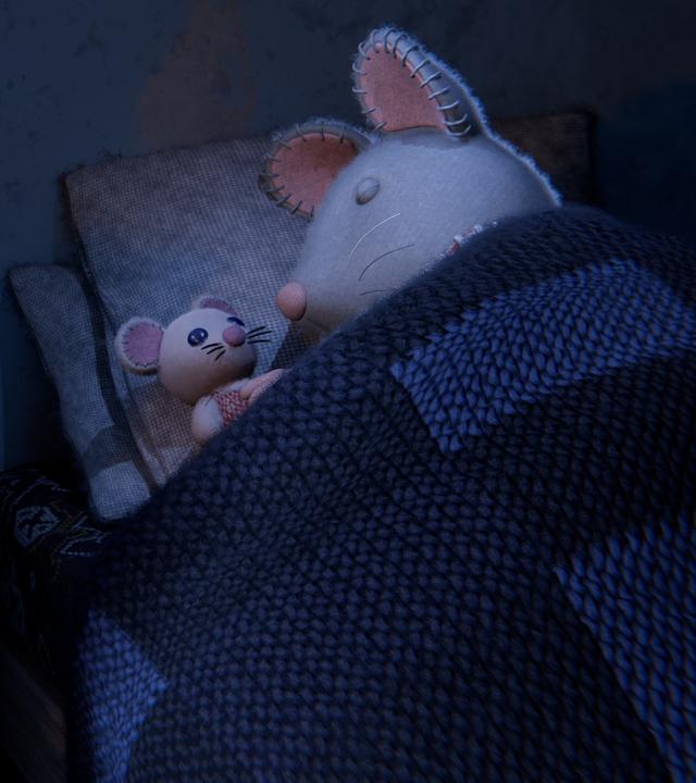 Julia liegt im Dunkeln zugedeckt mit ihrer Puppe neben sich im Bett und schläft. Auf dem Nachttisch steht der Traumfänger von Sam.