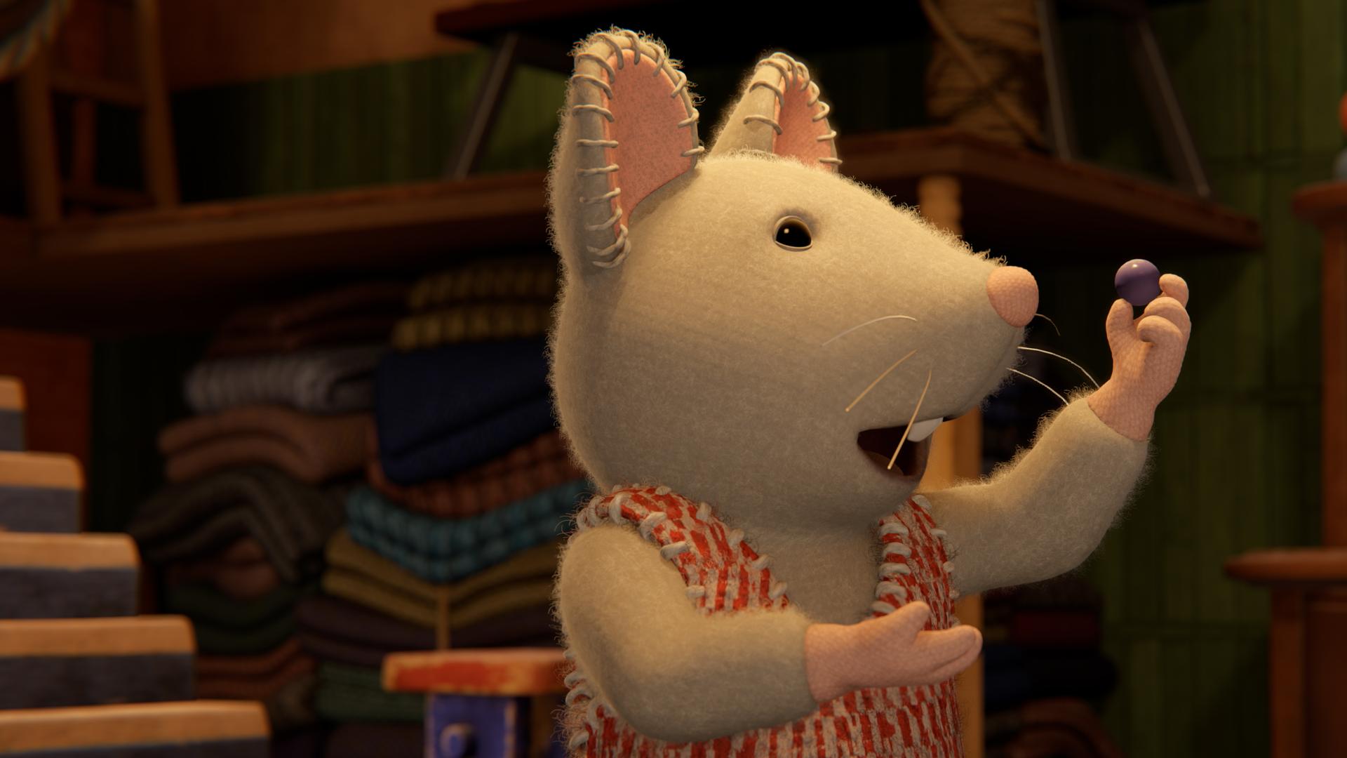 Julia steht in einem dunklen Keller und hält eine Murmel mit der linken Hand in die Höhe. Sie schaut erfreut auf die Murmel.