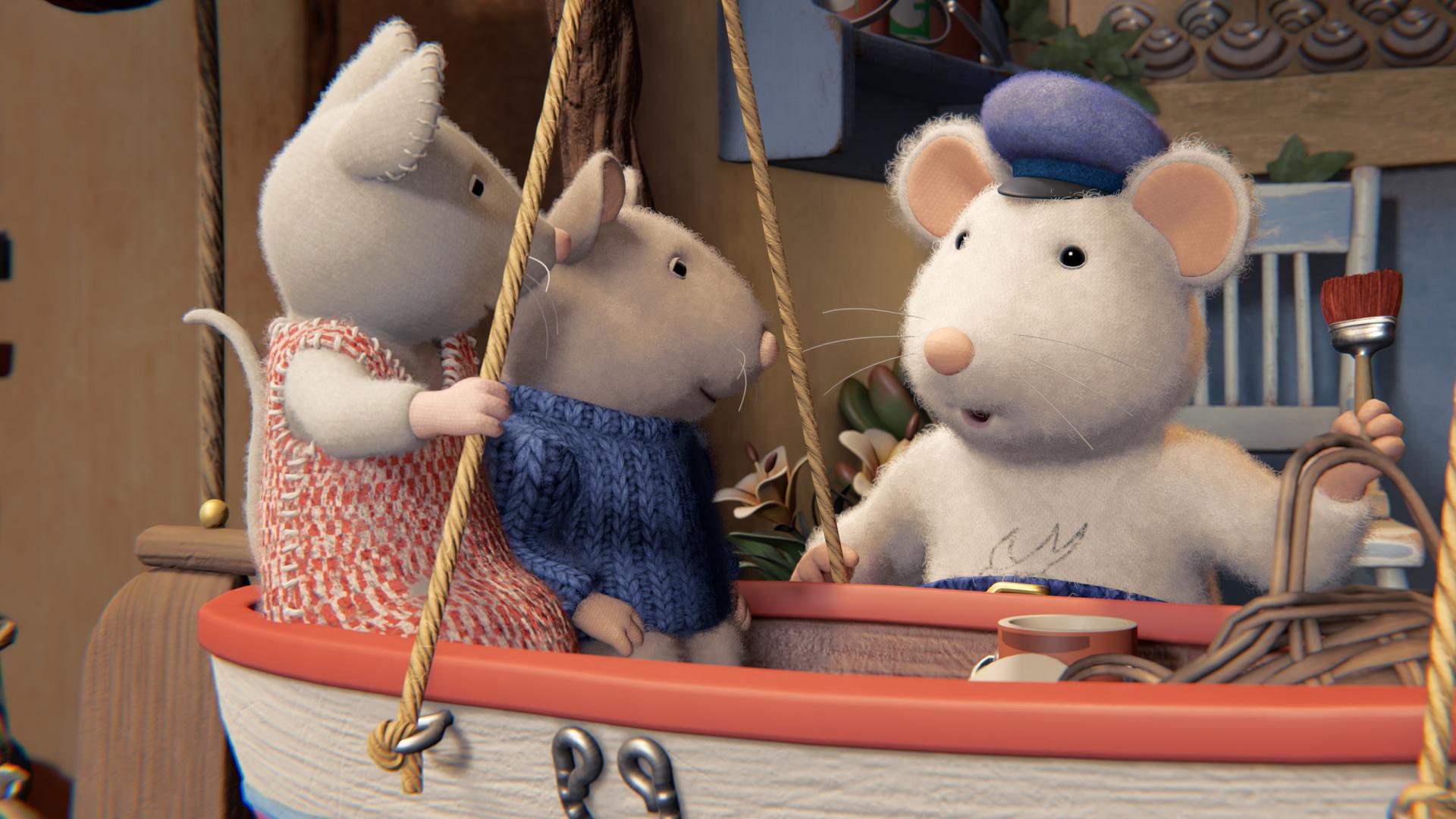 Opa Seemann steht vor einem Boot, das mit Seilen aufgehängt ist. Er wendet sich Sam und Julia zu, die hintereinander in dem Boot sitzen. 